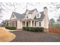 Well-maintained two-story home with manicured bushes, brick accents, and inviting front porch at 1008 Walnut Creek Dr, Woodstock, GA 30188