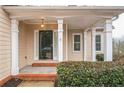 Welcoming front porch with classic columns, brick steps, and a dark front door at 1008 Walnut Creek Dr, Woodstock, GA 30188