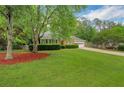 Attractive brick home with a green lawn, mature trees, and a driveway leading to an attached garage at 1050 Chestnut Hill Sw Cir, Marietta, GA 30064