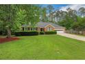Inviting single-story brick home with a well-maintained lawn and a driveway leading to a garage at 1050 Chestnut Hill Sw Cir, Marietta, GA 30064