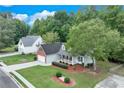 Aerial shot of a well-maintained home with mature trees, green lawn, and an inviting front porch at 3238 Sharp Creek Ln, Buford, GA 30519