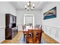 Formal dining room featuring hardwood floors, wainscoting, and a large window for natural light at 416 Wilfawn Way, Avondale Estates, GA 30002