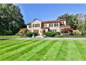 Beautiful exterior view of home with a vast lawn, mature trees, and manicured landscaping at 15 Cherokee Nw Rd, Atlanta, GA 30305