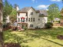 Backyard view featuring a deck, fenced yard and well-manicured lawn surrounded by mature trees at 1126 Gate Post Ct, Powder Springs, GA 30127