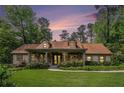Charming home with stone accents, dormer windows, a lush lawn, and mature landscaping at sunset at 351 Old Orchard Ct, Marietta, GA 30068