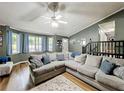 Bright living room with a large sectional, hardwood floors, and multiple windows providing lots of natural light at 505 Blake Dr, Douglasville, GA 30134