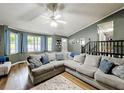 Spacious living room boasting a large sectional sofa, hardwood floors, and ample natural light from large windows at 505 Blake Dr, Douglasville, GA 30134