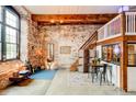 Open-concept living space with exposed brick, wood beams, and dining area at 170 Boulevard # H201, Atlanta, GA 30312