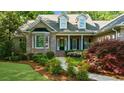 Inviting brick home featuring a covered porch, bay window, and professionally landscaped front yard at 3445 Strawberry Ln, Cumming, GA 30041