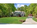 Beautiful brick house with a large front yard, mature trees, and circular driveway at 3445 Strawberry Ln, Cumming, GA 30041