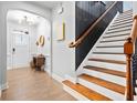 Bright entryway with wood floors and staircase featuring white risers and dark wood handrail at 2069 Brightleaf Way # 123, Marietta, GA 30060