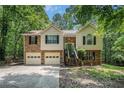 Inviting split-level home with stone accents, lush surroundings, two-car garage, and cozy entrance with wooden stairs at 300 Alcovy Way, Covington, GA 30014