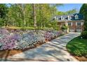 Brick home boasts immaculate landscaping with flower lined driveway at 4584 E Conway Nw Dr, Atlanta, GA 30327