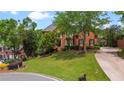 Attractive brick home with manicured lawn, mature trees, and a circular driveway for easy access at 6020 Ettington Dr, Suwanee, GA 30024