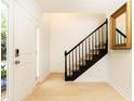 Clean foyer with a staircase, light wood flooring, and a decorative mirror at 911 Lenox Hill Ne Ct, Atlanta, GA 30324