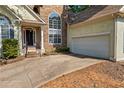 Front exterior showcasing stone details, a two-car garage, and a paved driveway at 115 Stonewall Dr, Covington, GA 30016