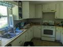 Cozy kitchen features a double sink, white cabinets, and all white appliances at 2291 Piney Grove Rd, Loganville, GA 30052