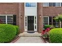 Close-up of the front door with sidelights, brick surround and colorful flower beds enhancing curb appeal at 4114 Suwanee Trail Dr, Buford, GA 30518