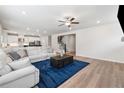Bright and open living room featuring hardwood floors, a ceiling fan, and a comfortable sofa at 2091 Landsburg Way, Lawrenceville, GA 30043