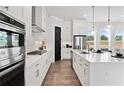 Modern kitchen showcasing white cabinetry, stainless steel appliances, and a large island with pendant lighting at 522 Pearl St, Cumming, GA 30040