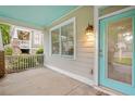 Charming home with a covered front porch, featuring a stylish turquoise door and complementary window trim at 1283 Mercer Ave, East Point, GA 30344