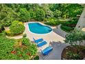 Outdoor pool area with lounge chairs and colorful landscaping provides a peaceful backyard retreat at 1550 Masters Club Dr, Sandy Springs, GA 30350