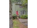 Two-story home with a bright pink door, green siding, and mature landscaping at 6 Holly Downs Nw Ct, Atlanta, GA 30318