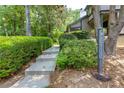A long walkway leading up to a two story home, landscaped with thick bushes and mature trees at 3102 Balearic Se Dr, Marietta, GA 30067