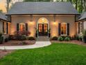 Close-up of the front door with decorative lighting, landscaping and well-kept lawn at 4643 River Ct, Peachtree Corners, GA 30097