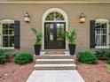 Elegant entryway featuring a double door, exterior lanterns and manicured shrubbery at 4643 River Ct, Peachtree Corners, GA 30097