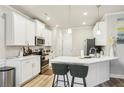 Well-lit kitchen featuring white cabinets, stainless steel appliances, and a breakfast bar at 5575 Rock Place Ct, Norcross, GA 30093