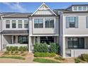 Well-maintained townhome with covered porch and manicured landscaping at 677 Stickley Oak Way, Woodstock, GA 30189