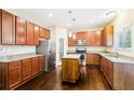 Kitchen with granite countertops, stainless steel appliances, central island, and pantry at 1647 Shire Village Dr, Sugar Hill, GA 30518