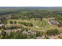 Aerial view of property located on a golf course surrounded by lush greenery and mature trees at 5293 Aldeburgh Dr, Suwanee, GA 30024