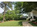 Lovely landscaped front yard with a charming walkway leading to a white painted brick home at 26 Kensington Rd, Avondale Estates, GA 30002
