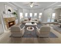 Bright living room featuring a fireplace, large windows, and neutral decor at 4449 Sierra Creek Dr, Hoschton, GA 30548