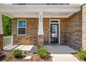Inviting front porch featuring brick accents and a well-lit entryway to the home at 6900 Oak Valley Dr, Douglasville, GA 30134