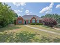 Charming one-story brick home boasts a well-manicured lawn and mature trees, offering great curb appeal at 6455 Crystal Ln, Cumming, GA 30040