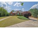 This home boasts a large front yard with a charming brick facade and perfectly trimmed landscaping at 6455 Crystal Ln, Cumming, GA 30040