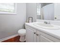 Cozy bathroom featuring white fixtures and warm wood floors at 7245 W Strickland St, Douglasville, GA 30134