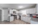 Modern kitchen with stainless steel appliances, sleek white cabinets, and gray countertops at 7245 W Strickland St, Douglasville, GA 30134