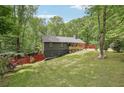 A charming home nestled among lush trees with a well-manicured lawn, offering a serene and private setting at 1490 Ashbrook Dr, Lawrenceville, GA 30043