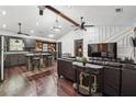 An open-concept living room featuring ceiling fans, dark furniture, and hardwood floors throughout the home at 1490 Ashbrook Dr, Lawrenceville, GA 30043
