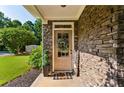 Stone front porch with a neutral door, decorative wreath and 'welcome' sign at 301 Downing Creek Trl, Canton, GA 30114