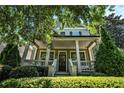 Charming two-story home boasting a covered front porch with lush landscaping, creating a welcoming curb appeal at 647 East Ne Ave, Atlanta, GA 30312