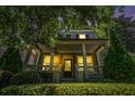 Inviting two-story home featuring a covered porch with bright lighting and lush landscaping, creating a warm ambiance at 647 East Ne Ave, Atlanta, GA 30312