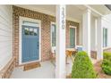 Inviting front porch with rocking chairs, a brick facade, and a blue front door at 2360 Charleston Manor Ln, Suwanee, GA 30024
