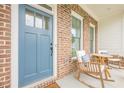 Close up view of the front porch with rocking chairs and a charming blue door at 2360 Charleston Manor Ln, Suwanee, GA 30024