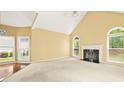 Bright living room features a fireplace, neutral carpet, and arched windows at 3187 Gainer Dr, Powder Springs, GA 30127
