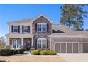 Charming two-story home with a stone facade, three-car garage, and well-manicured lawn at 496 Spring View Dr, Woodstock, GA 30188